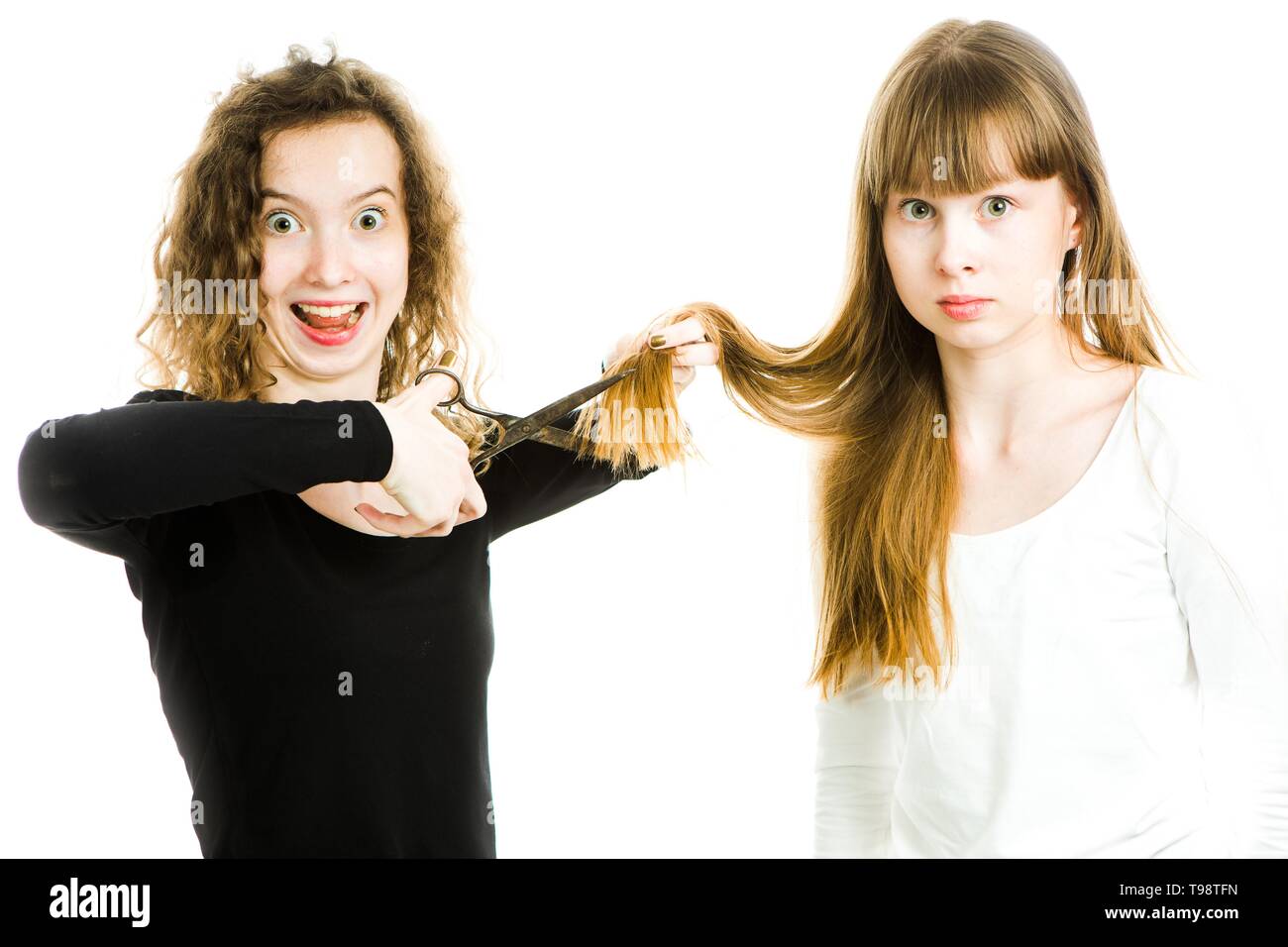 Zwei Mädchen mit blonden Haaren und Schere, man Haare besser Haarschnitt - junge Friseur - weißer Hintergrund zu machen Stockfoto