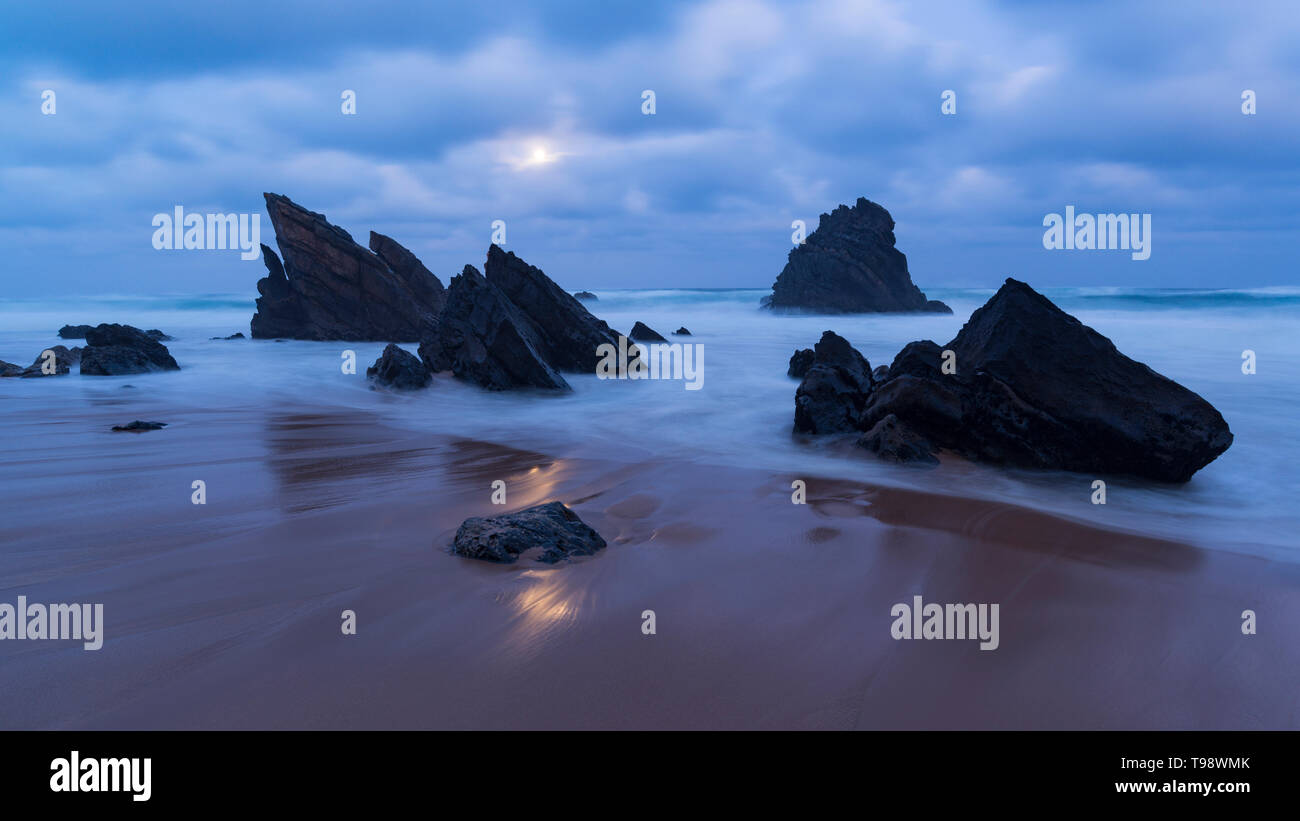 Mondlicht auf Sandstrand mit Felsformationen, Praia da Adraga, Sintra, Portugal Stockfoto