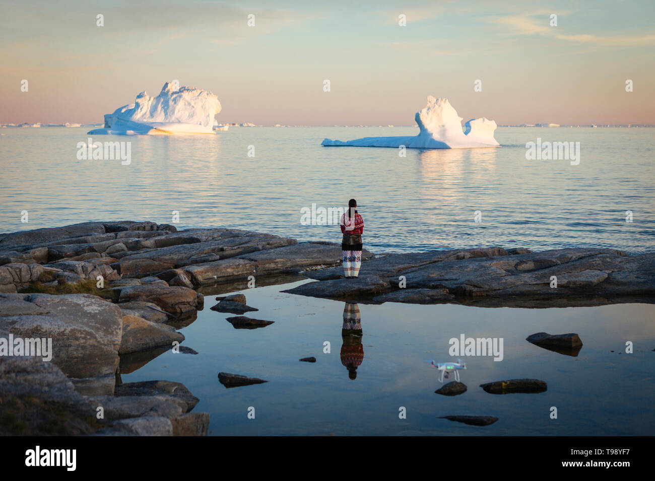 Inuit Frau in traditioneller Kleidung steht am Ufer der Diskobucht auf Mittsommer, Grönland Stockfoto