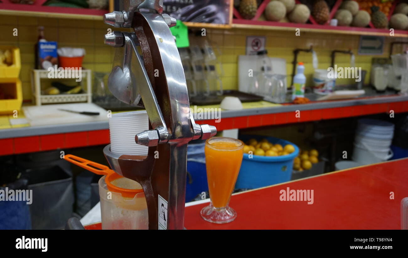 Jugos Canadå, Mexiko Stadt. Saftbar. Hohes Glas Orangensaft auf sauberen roten Zähler sitzt in einem schönen Entsafter juice Bar zu Chrom. Stockfoto