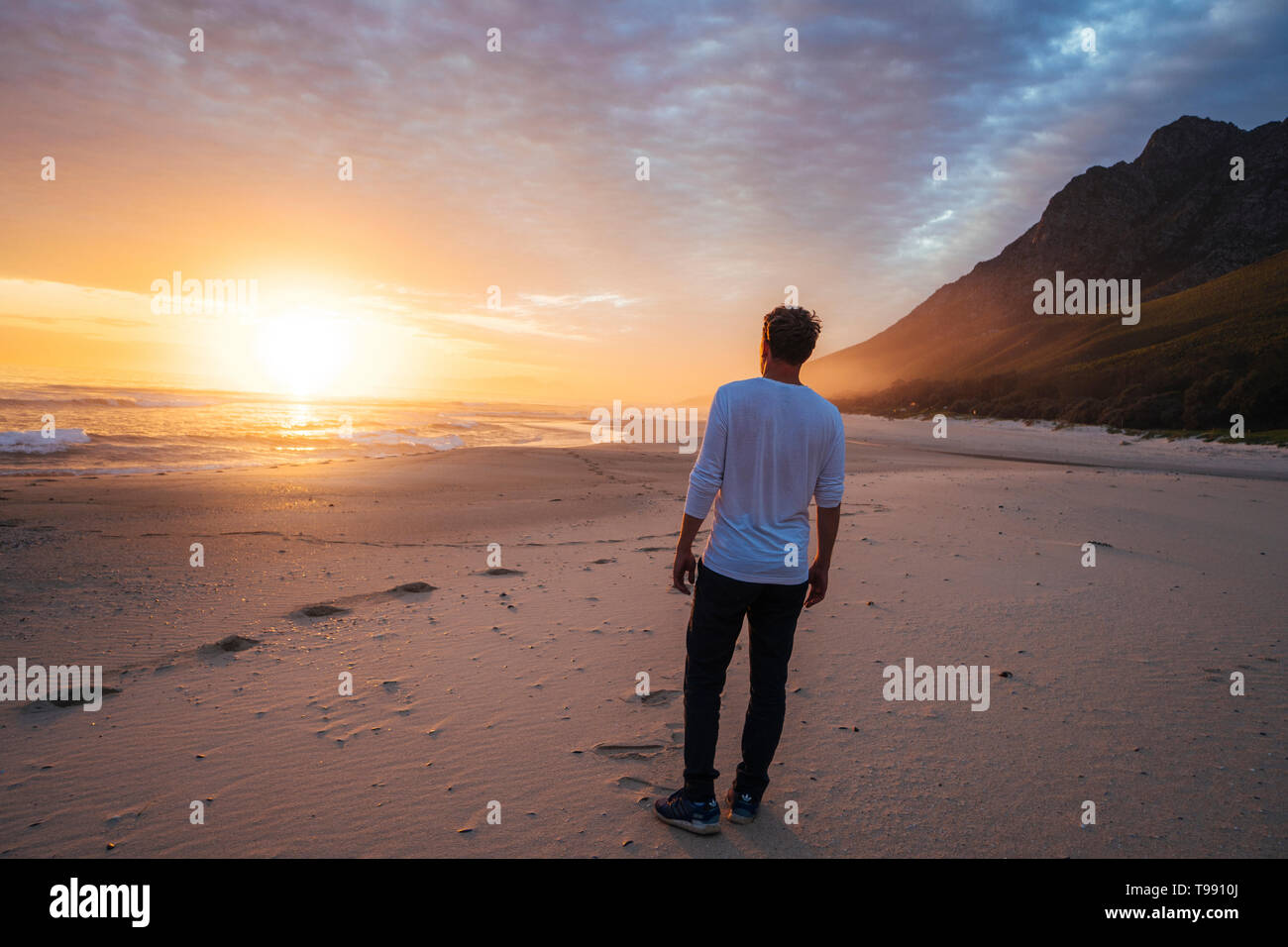 Mann am Strand bei Sonnenuntergang, Western Cape, Südafrika Stockfoto