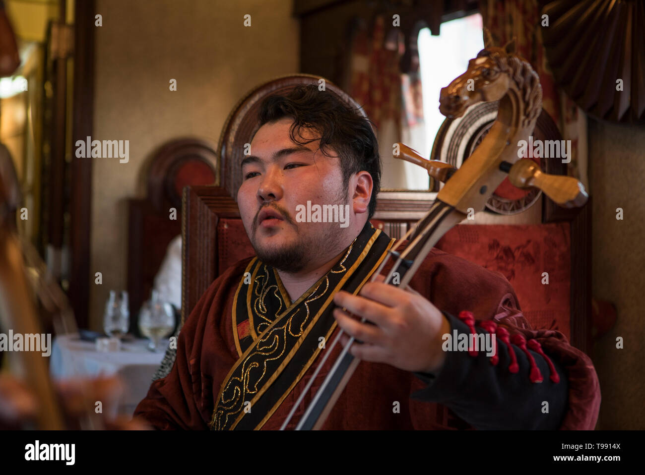 Mongole spielt Instrument im Speisewagen, Transsibirische Eisenbahn, Bügeleisen Stockfoto