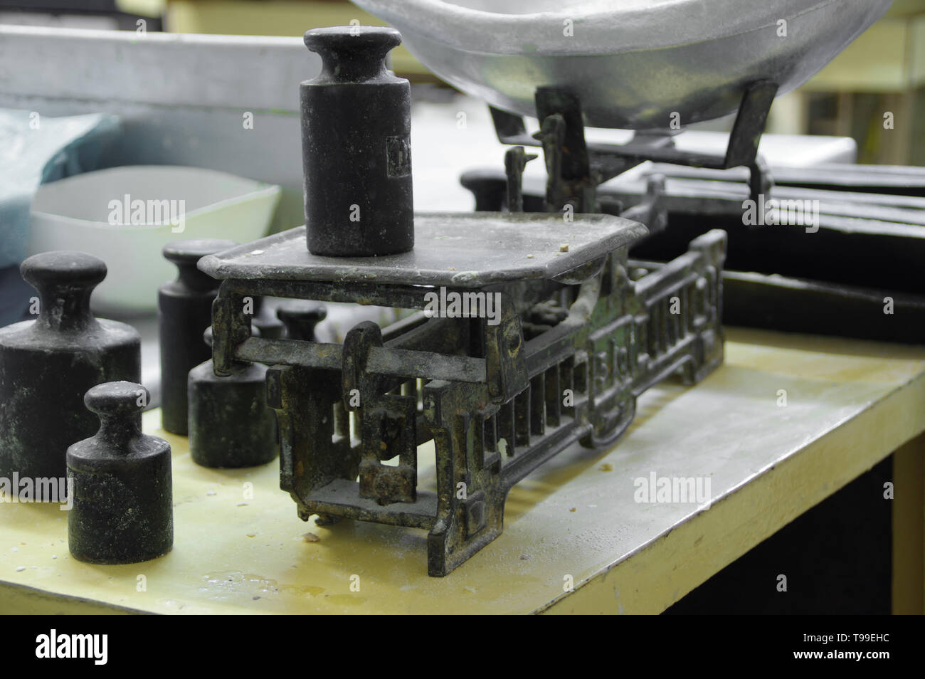 Alte Waage mit Gewichten und einer Schüssel mit Mehl. Retro Ausrüstung in die Bäckerei. Vintage-Technologie. Stockfoto