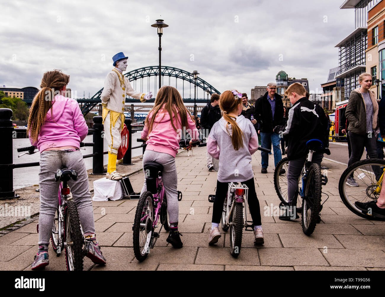 Ansicht der Rückseite des Gruppe Kinder Fahrrad Kai street Entertainer vor Ihnen, Kai, Newcastle upon Tyne, England, Großbritannien Stockfoto