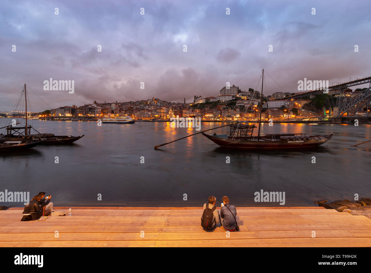Blick über den Rio Douro in der Dämmerung nach Porto mit traditionellen Hafen Boote im Vordergrund. Stockfoto
