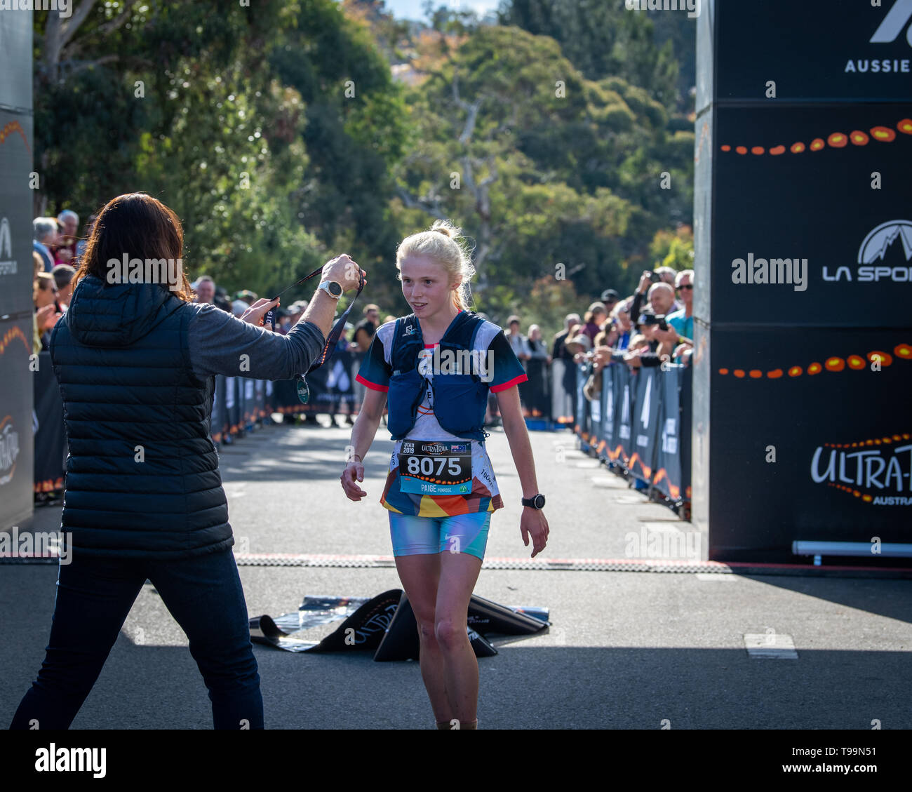 Blue Mountains, Australien - 16 April 2019: ultra-trail Australien UTA 11 Rennen. Runner Paige Penrose, über alle Sieger der Fall der Frauen, nimmt Medaille bei der Stockfoto
