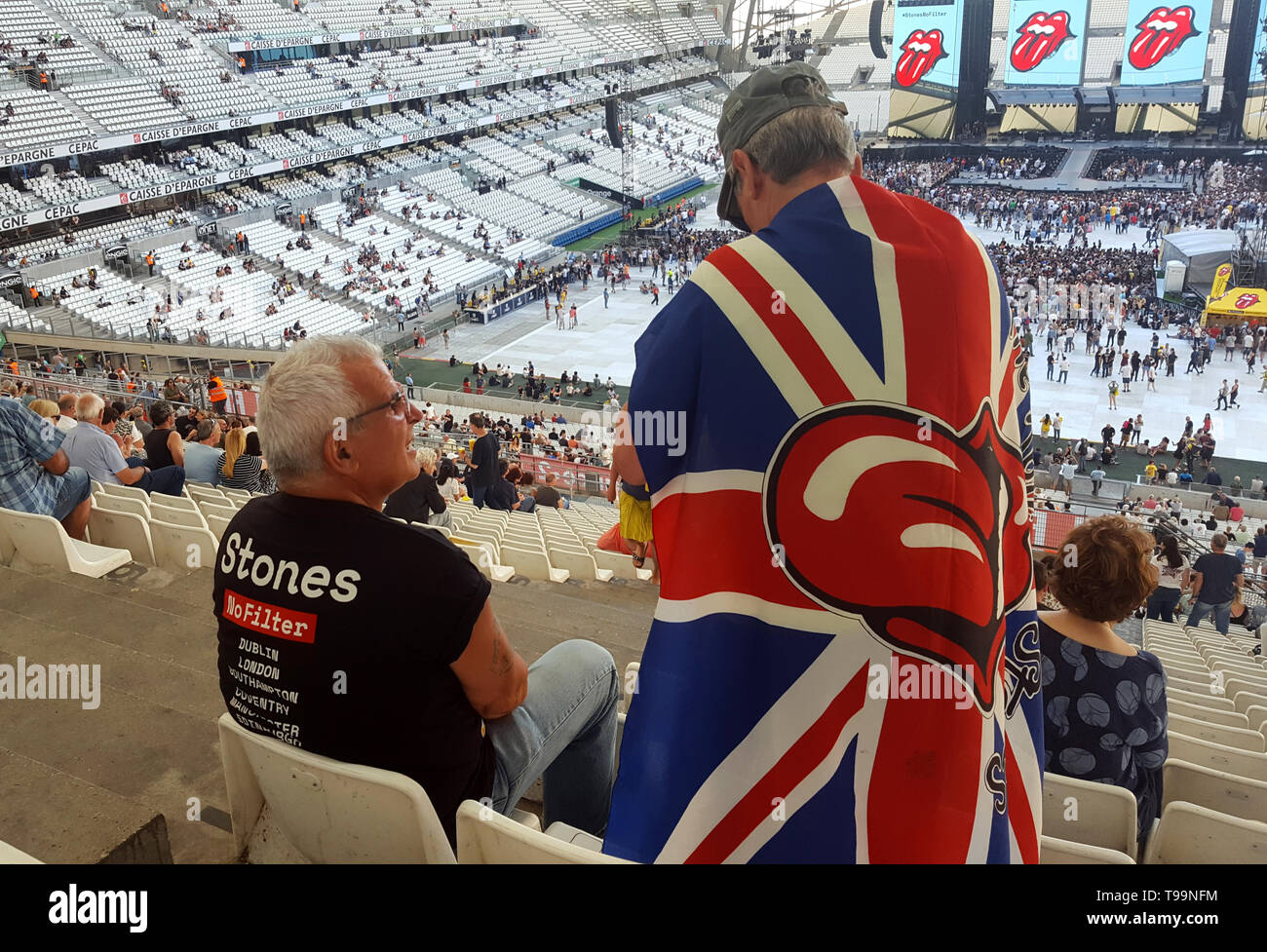 Rolling Stones Rock Musik Fans, eine mit der Union Jack Flagge drapiert, warten Sie, bis der Start von einem Konzert der Rolling Stones während der legendären Gruppe kein Filter Tour im Velodrome Stadion Marseille (26. Juni 2018) Stockfoto