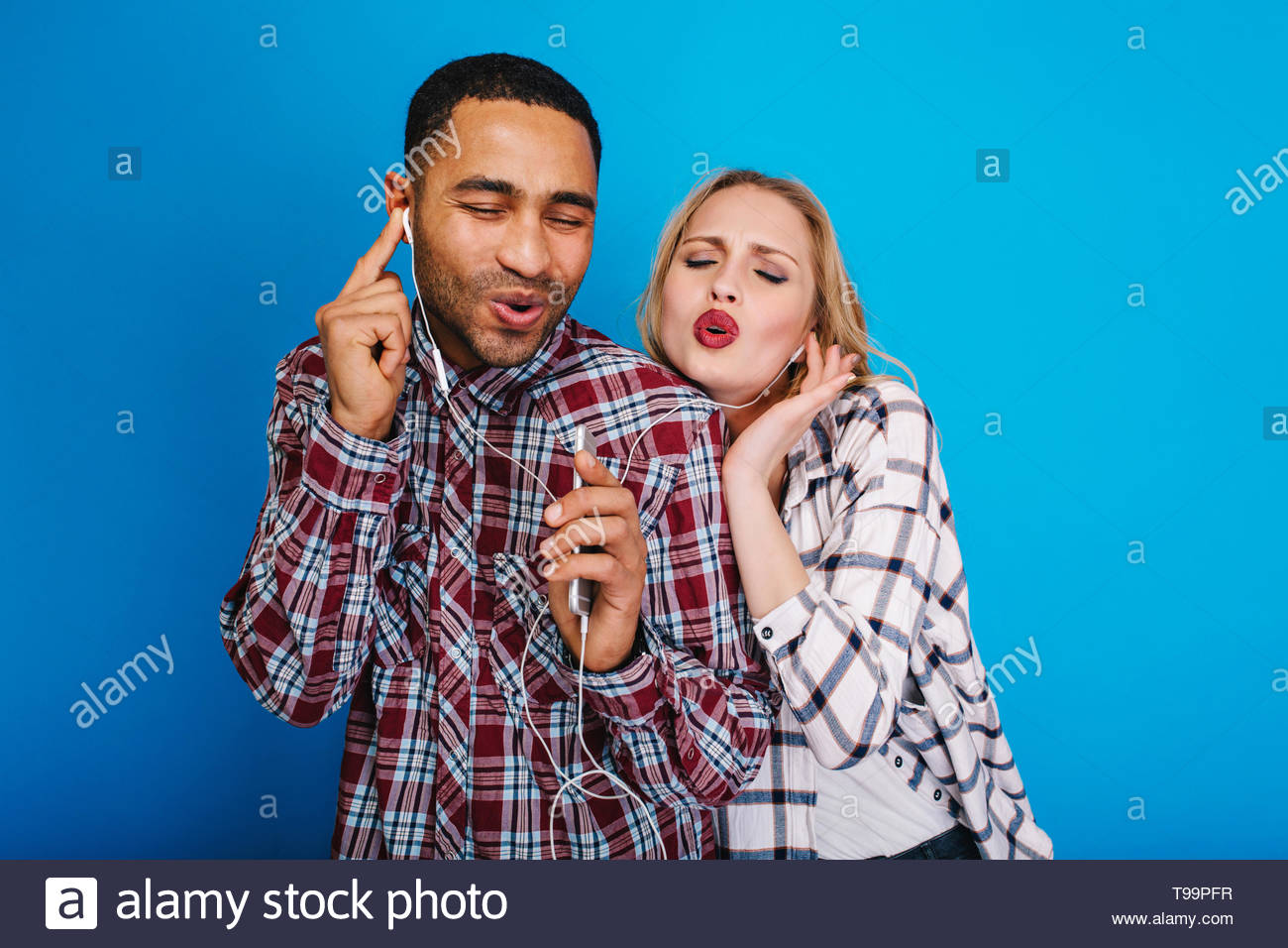 Portrait Aufgeregt Freudiges Paar Horen Von Musik Uber Kopfhorer Auf Blauem Hintergrund Spass Singen Mit Geschlossenen Augen Geniessen Zum Ausdruck Positivitat Lieder Freie Zeit Entspannend Stockfotografie Alamy