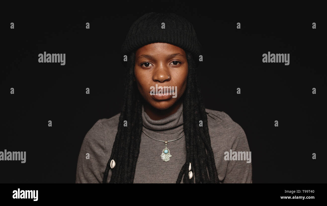 Portrait der afrikanischen Frau in T-shirt mit langen Dreadlocks. Porträt der afrikanischen Frau auf schwarzem Hintergrund isoliert. Stockfoto