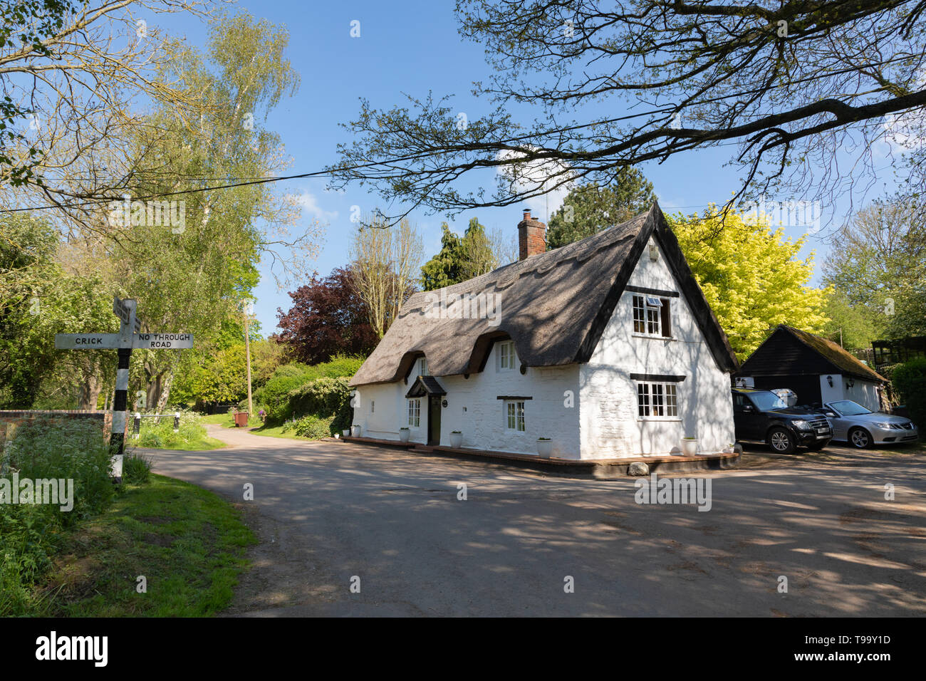 Bridge Cottage, einem malerischen, Denkmalgeschützte, strohgedeckten Gebäude steht an einem Scheideweg in der kleinen und hübschen Northamptonshire Dorf Winwick. Stockfoto