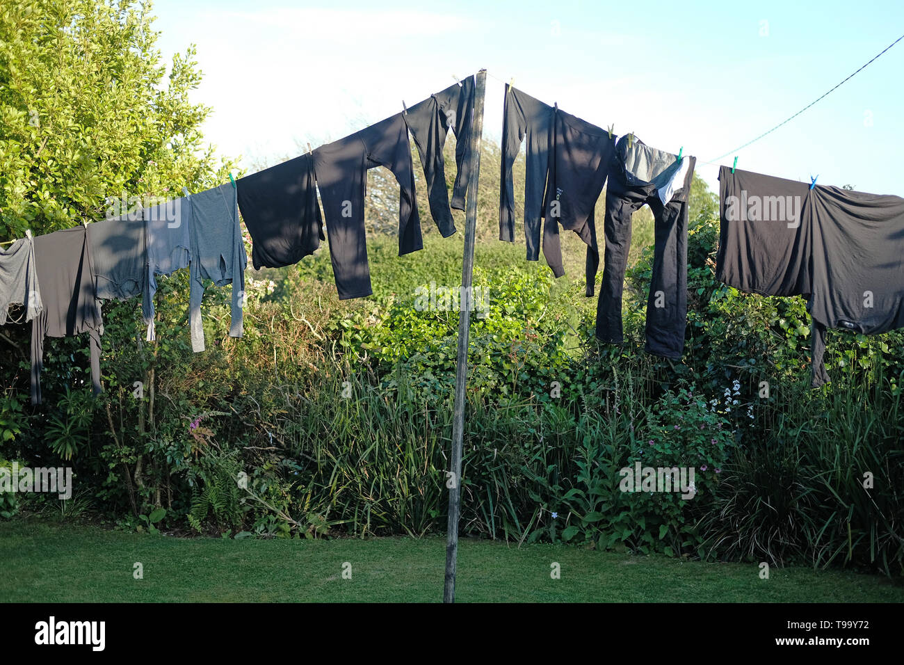 Alle graue und schwarze Kleidung hängend auf einer Wäscheleine. Stockfoto
