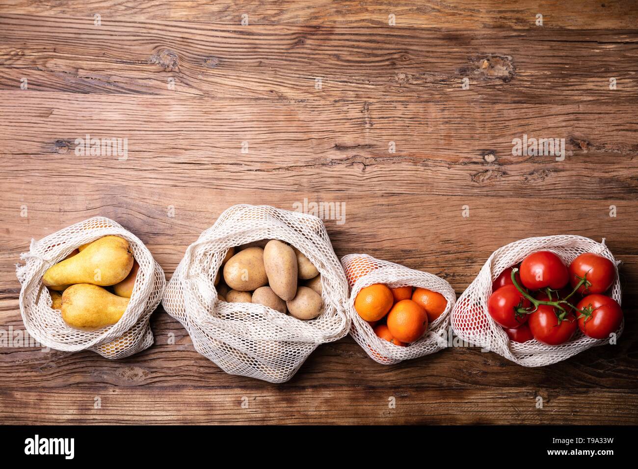 Eine Ansicht von Gemüse und Früchten in der Tasche über Holz- Schreibtisch Stockfoto
