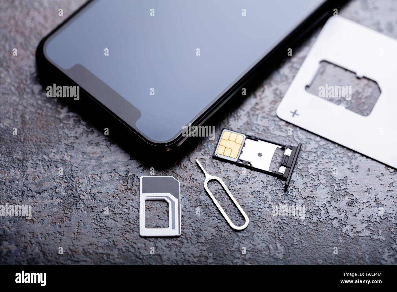 Handy in der Nähe von Nano-SIM-Karte in den Card Adapter mit Eject Pin über konkreten Hintergrund Stockfoto