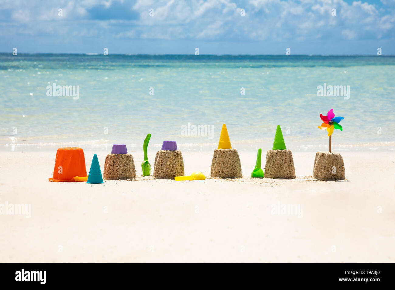 Spielzeug mit bunten Windrad Vor Meer auf Sand am Strand Stockfoto