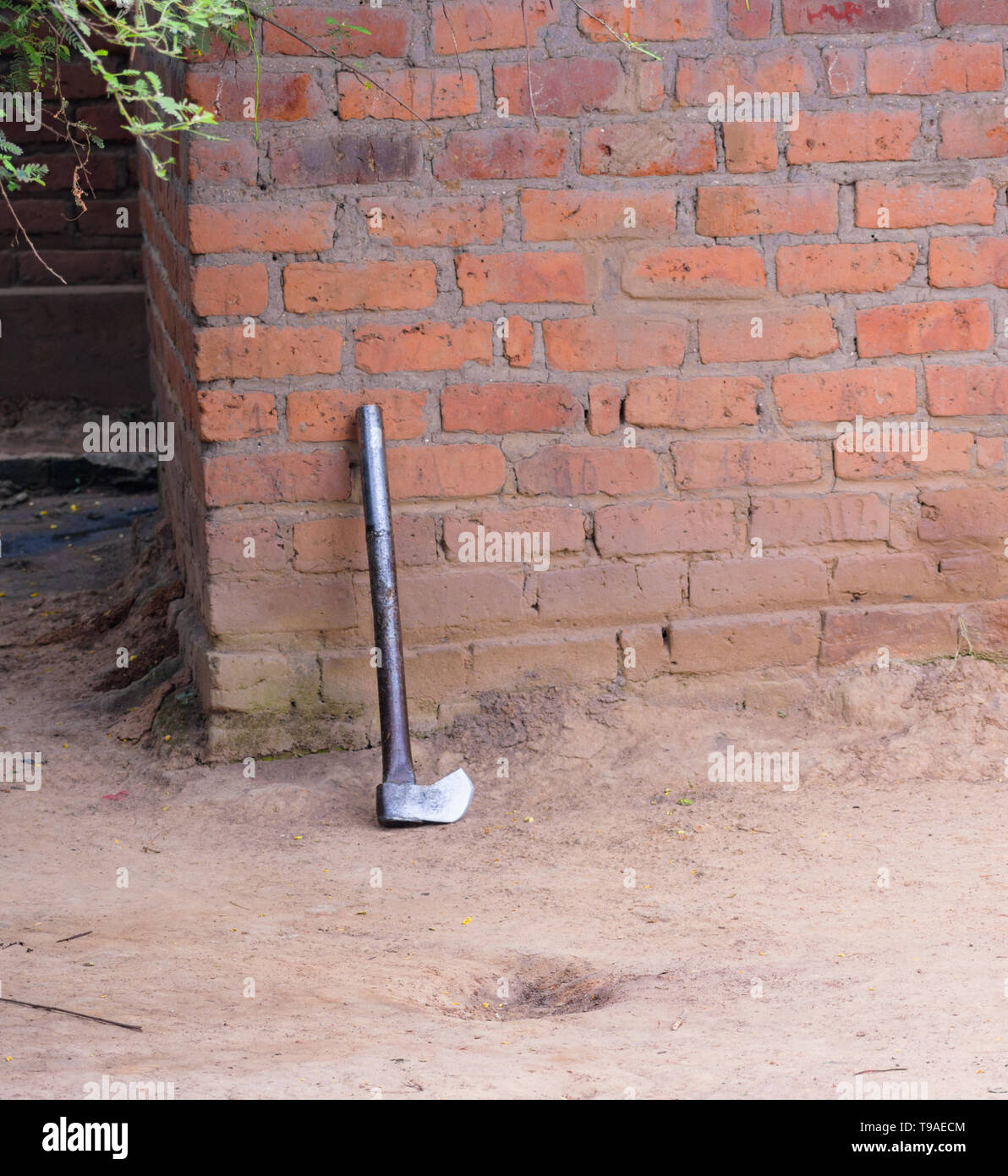 Ein großes metallisches ax Linke lehnte sich gegen eine Wand nach dem Zerkleinern von Brennholz Stockfoto