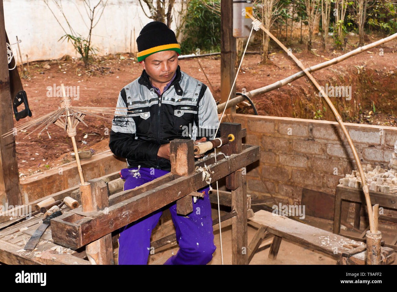 Ein junger Burmese, der Teile für handgefertigte traditionelle Holzschirme, Myanmar, anfertigte Stockfoto