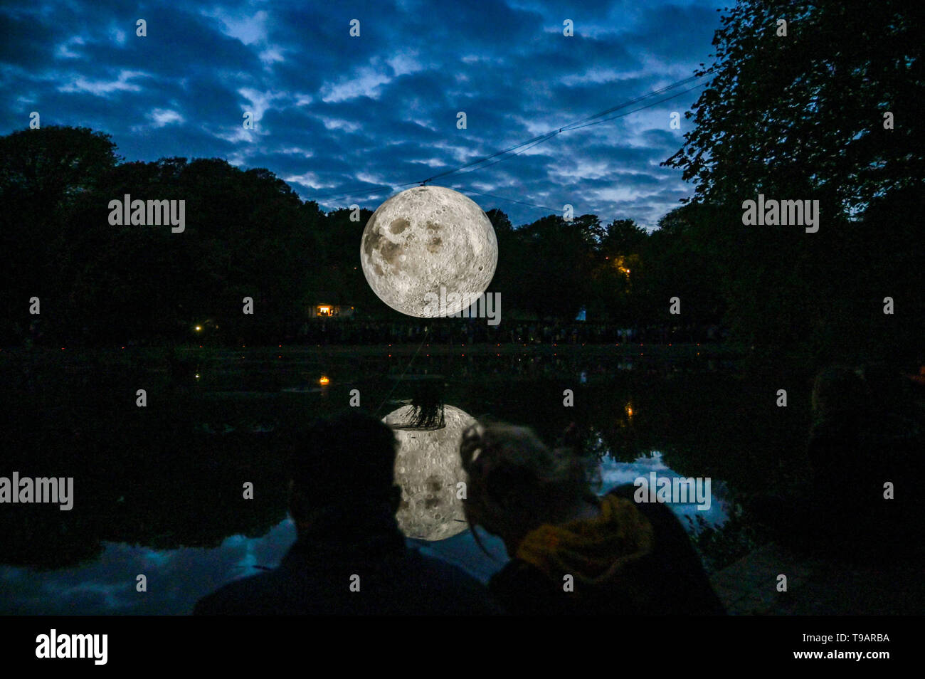 Brighton UK 17. Apr 2019 - Massen um Queens Park Teich in Brighton versammelten sich an diesem Abend das Brighton Festival Veranstaltung 'Museum der Mond' des Künstlers Luke Jerram, die zum 50. Jahrestag der Mondlandung gefeiert zu beobachten. Der Mond beleuchtet, über das Wochenende werden, begleitet von Musik des Komponisten Dan Jones. Foto: Simon Dack/Alamy leben Nachrichten Stockfoto