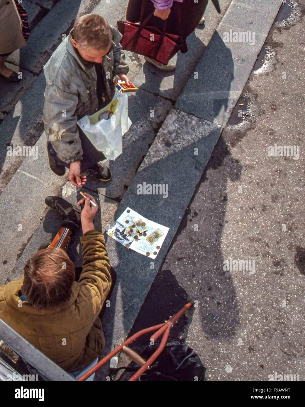 Moskau, Russland. 25 Sep, 1992. Leben auf Moskaus Straßen nach der UDSSR zusammengebrochen. Eine beinlose Bettler akzeptiert eine Zigarette von einem Passanten. Credit: Arnold Drapkin/ZUMA Draht/Alamy leben Nachrichten Stockfoto