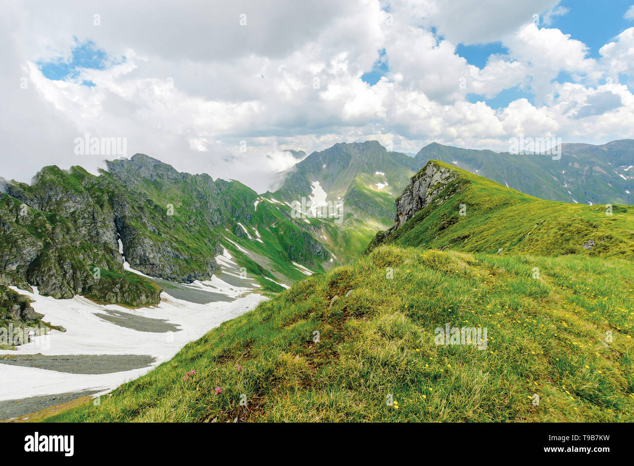 Fagaras Bergrücken im Sommer. Flecken Schnee auf Gras auf steilen Hang. felsigen Gipfeln. Wetter. Rumänien Landschaft Stockfoto