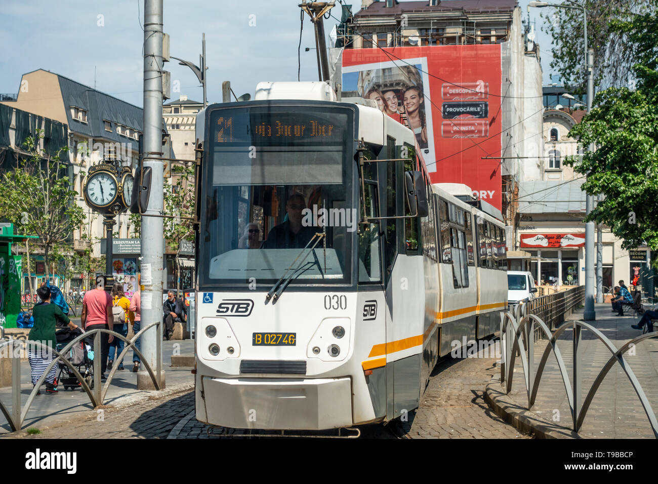 Eine dreigeteilte Straßenbahn, die Route 21, in Piata Sf Georghe (St George Square) im Stadtgebiet Der Altstadt von Bukarest, Rumänien. Menschen gehen und entspannen Stockfoto