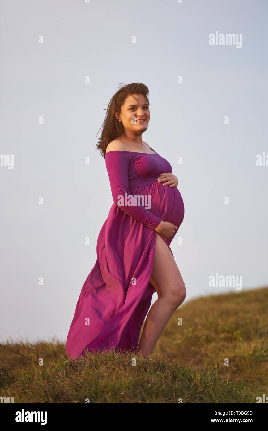 Schwangerschaft der jungen Frau. Frau im rosa Kleid Stockfoto