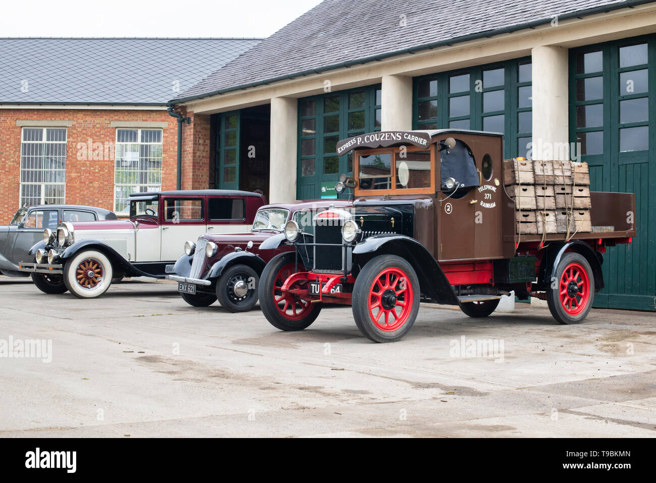 Oldtimer Lkw und Autos außerhalb einer Garage im Bicester Heritage Center 'Drive es Tag'. Bicester, Oxfordshire, England. Stockfoto