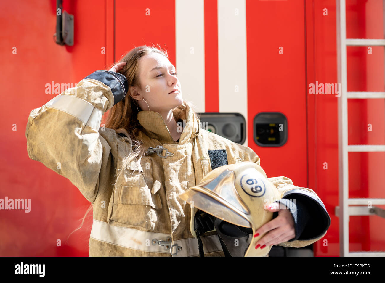 Foto auf der Seite des Feuers blonde Frau, die in der Nähe von Feuer Lkw Stockfoto