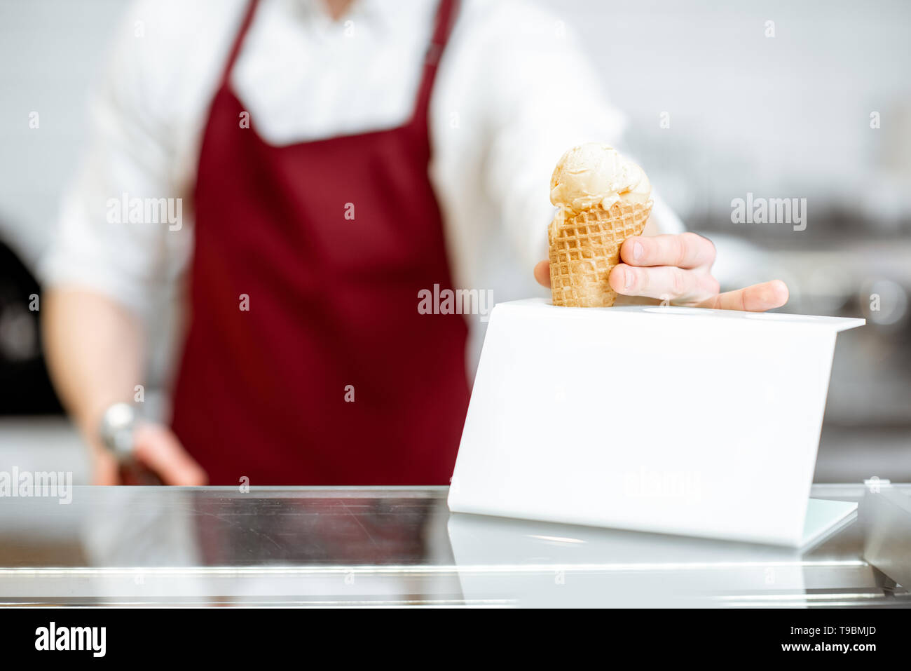 Verkäufer setzen Eis in die Weiße stehen auf der Showcase im Shop Stockfoto