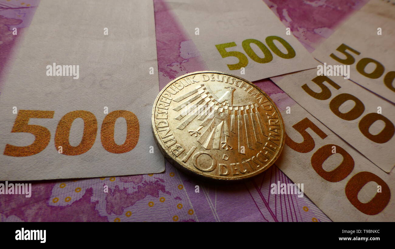 Eine westliche zehn Deutsche Mark Münze wird auf 500 Euro Banknoten Stockfoto
