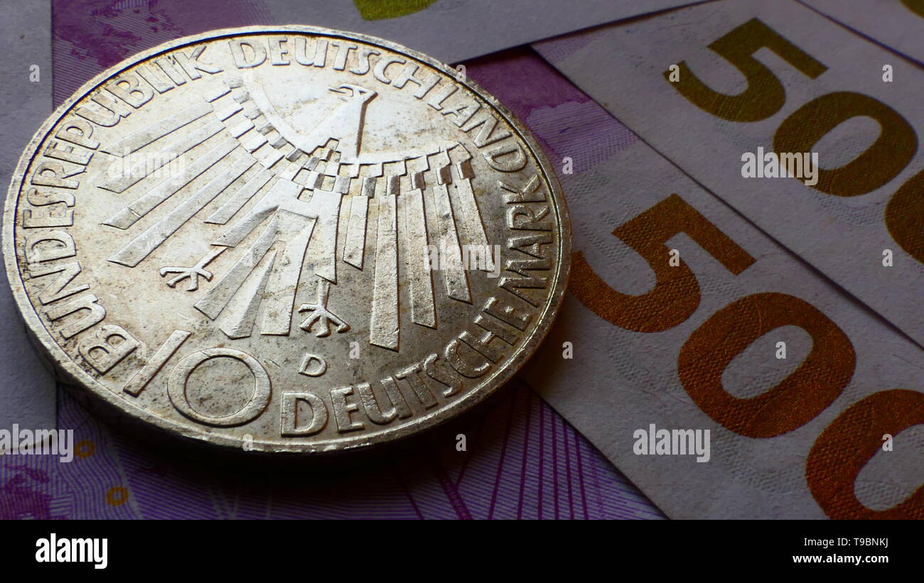 Nahaufnahme von einer westlichen zehn Deutsche Mark Münze, mit neuen 500-Euro-Banknoten im Hintergrund Stockfoto