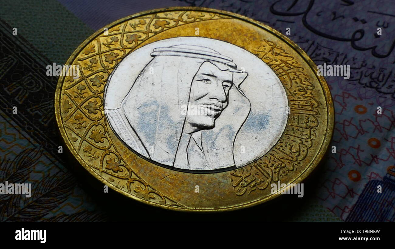 Nahaufnahme von der Rückseite der eine saudische Riyal Münze mit mehreren Riyal Banknoten im Hintergrund Stockfoto