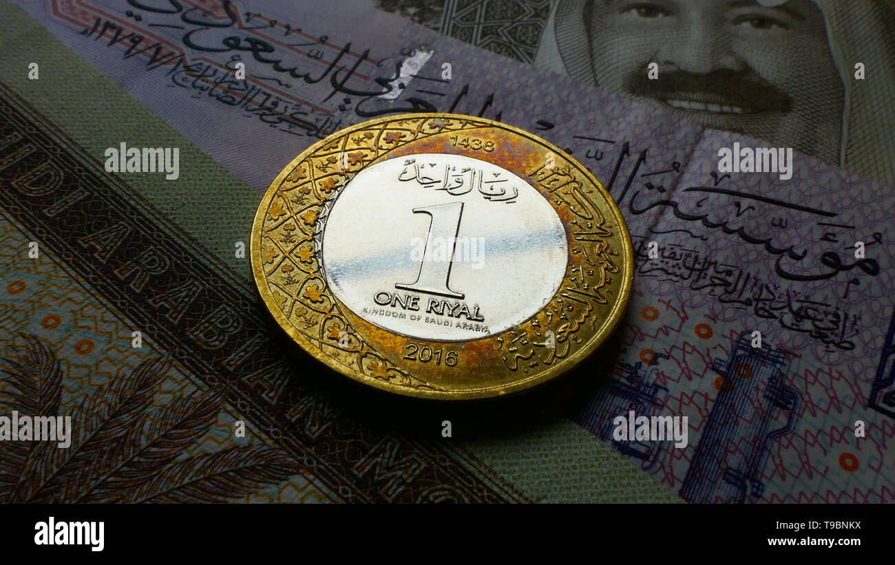 Nahaufnahme von der Vorderseite der Münze ein Saudischer Rial mit mehreren Riyal Banknoten im Hintergrund Stockfoto