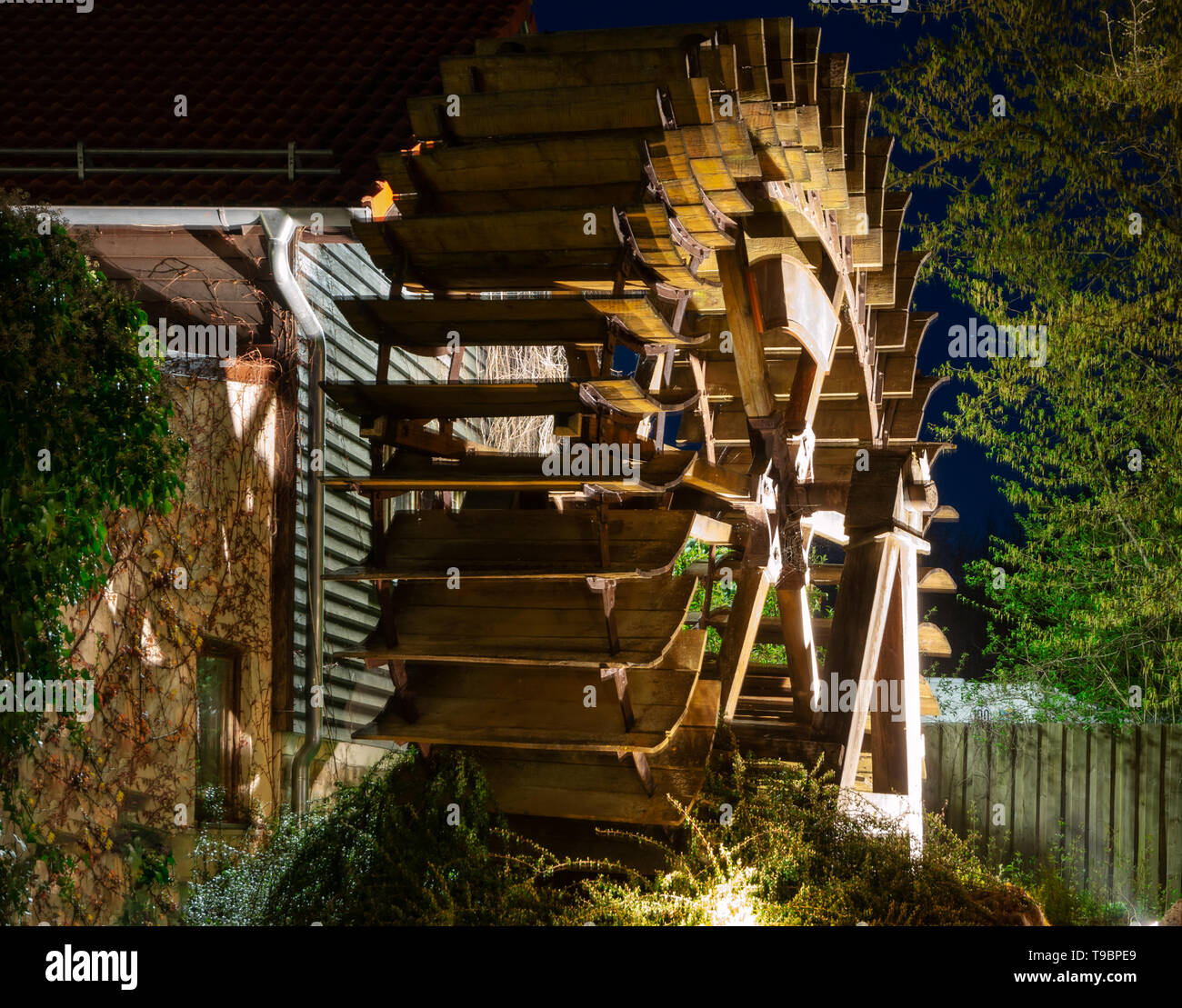 Vintage Holz- beleuchtetes Wasserrad bei Nacht Stockfoto