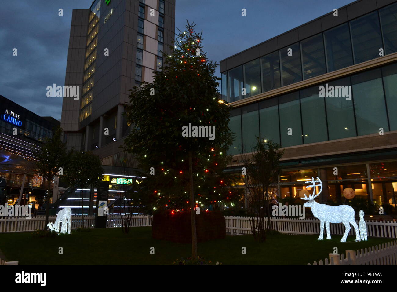 London/Großbritannien - 15. Dezember 2014: phosphoreszierende Hirsche gehen um Weihnachtsbaum in Westfield Stratford City Shopping Center installiert. Stockfoto
