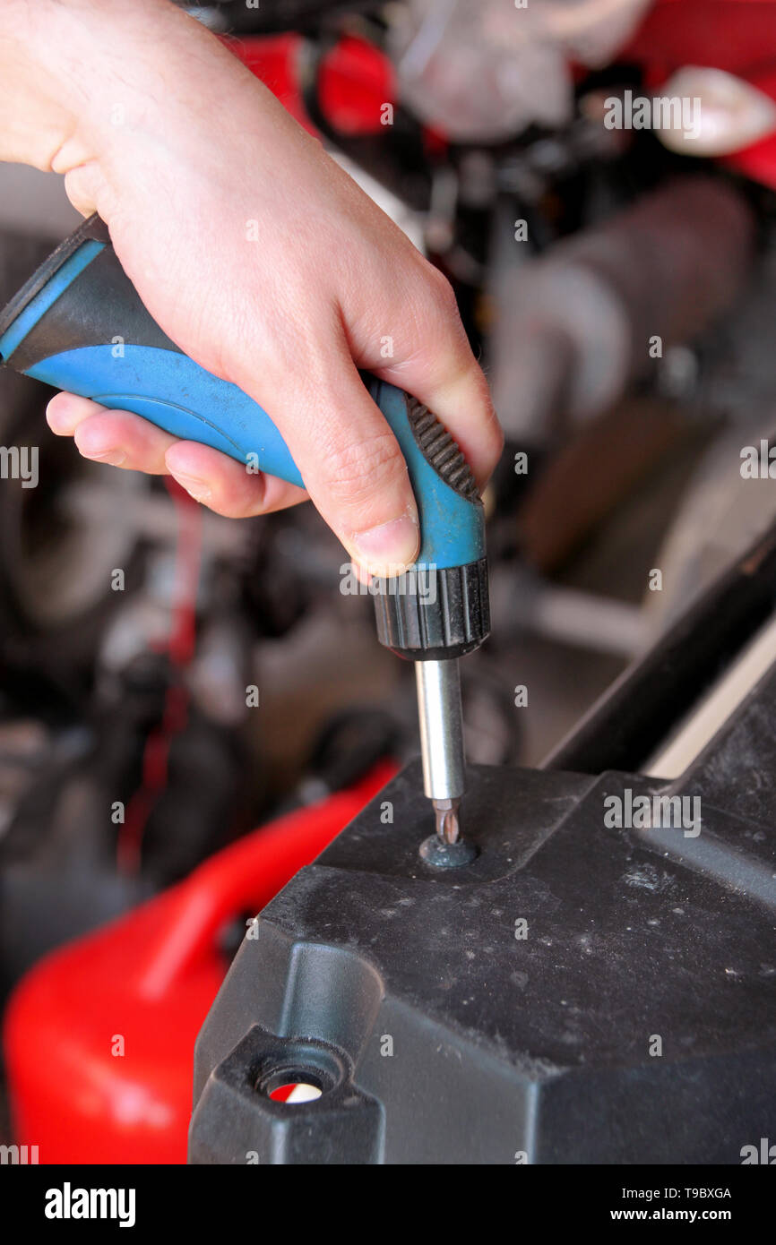Kfz Mechaniker und Meister ist, schrauben Sie eine Schraube mit blauen  Schraubendreher in automechanics Werkstatt. Es wurden die Hände der  Automechaniker Stockfotografie - Alamy