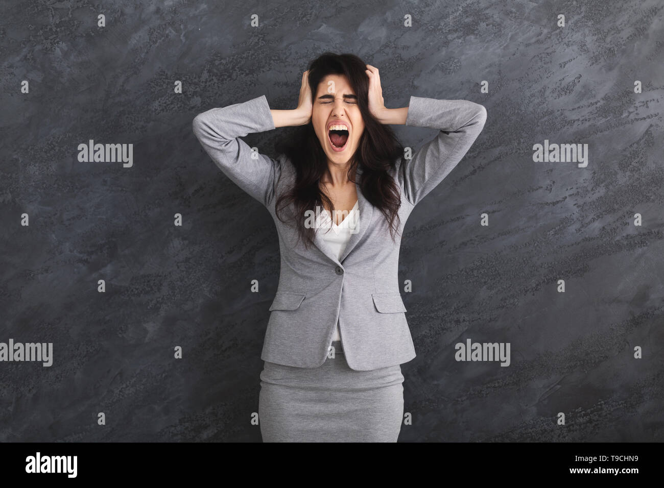 Emotionale Wut Geschäftsfrau Schreien über grauer Hintergrund Stockfoto