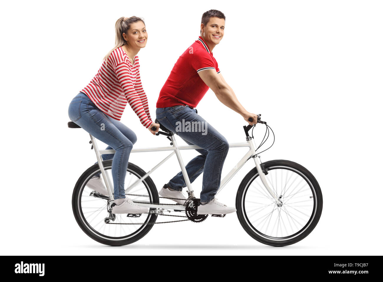 Volle Länge geschossen von einem jungen Mann und Frau auf einem Tandem Fahrrad an der Kamera auf weißem Hintergrund suchen Stockfoto