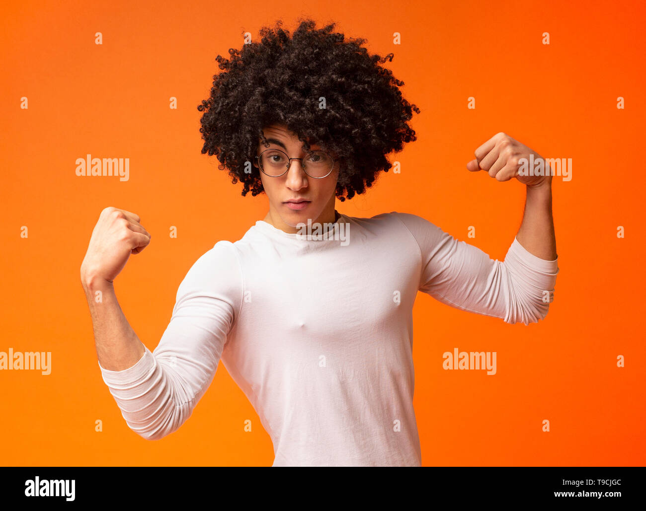 Super starken schwarzen Kerl zeigen Bizeps auf orange Hintergrund Stockfoto