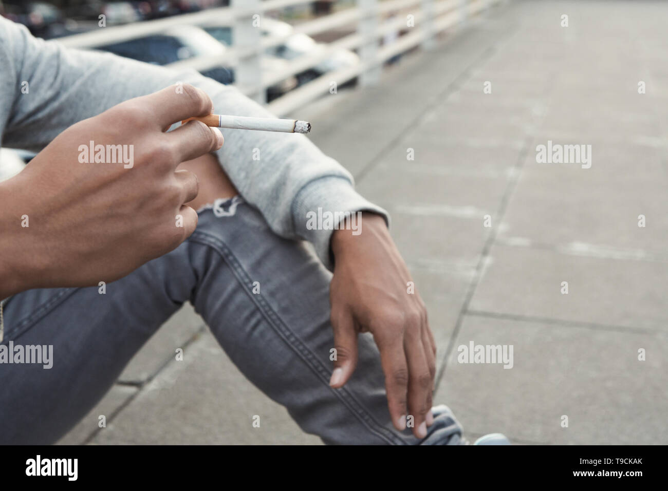 Jugendlich Ausgaben. Schwarzer jugendlicher Raucher Zigarette, allein sitzen Stockfoto