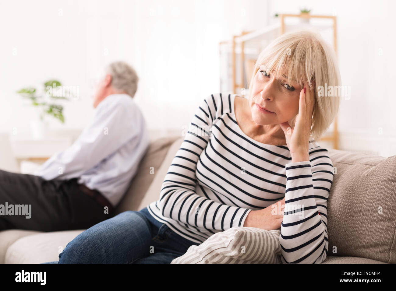 Ältere Paare in Beziehung Probleme, auf gegenüberliegenden Seiten suchen Stockfoto