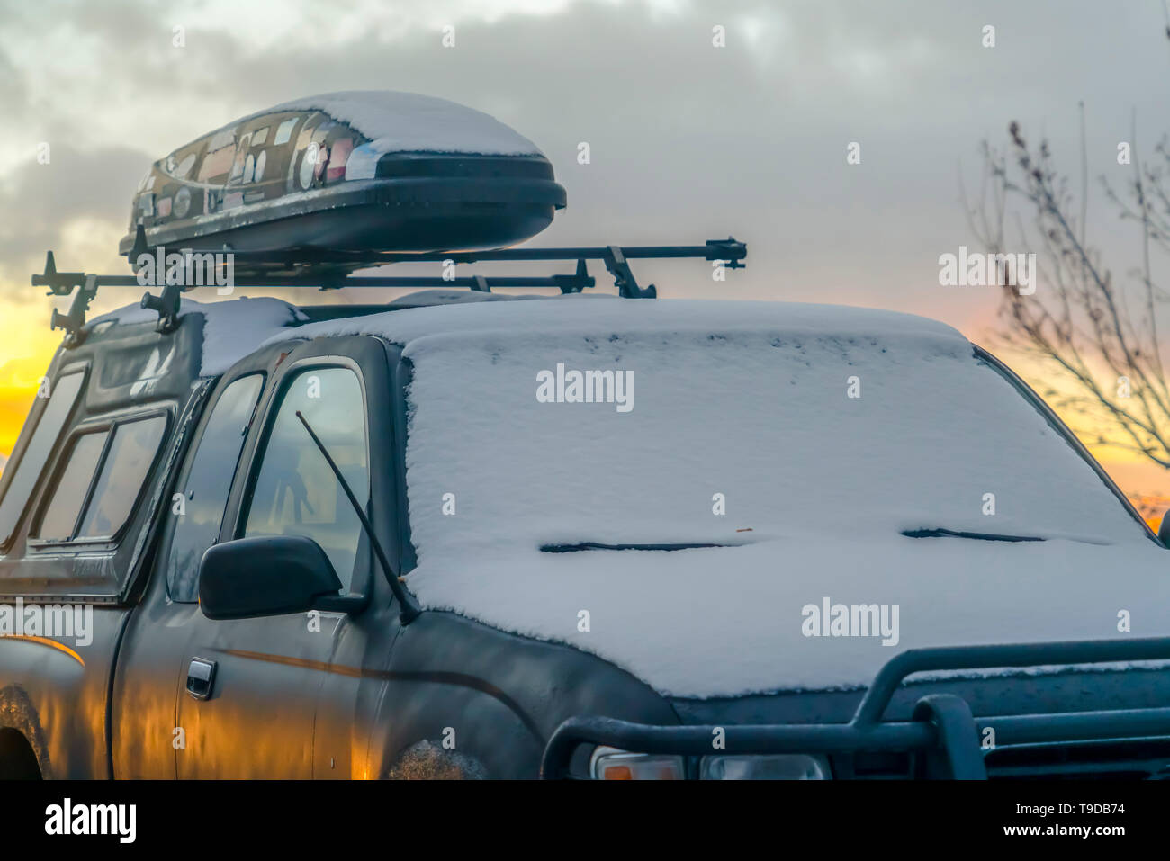 Schwarze Fahrzeug mit einem Dachgepäckträger und Dachterrasse Cargo Carrier im Winter gesehen Stockfoto