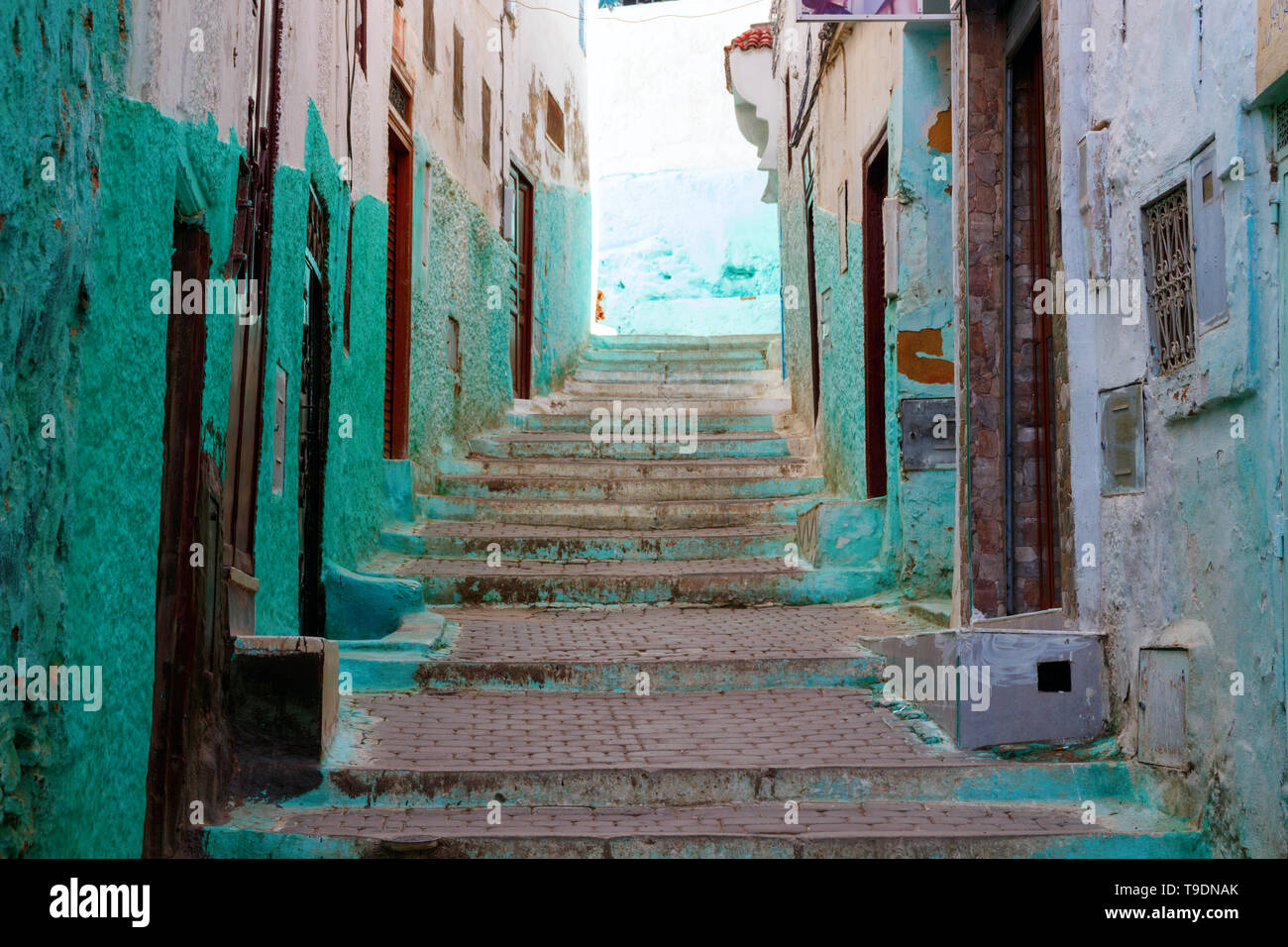 Gasse im Zentrum der kleinen Stadt Moulay Idriss Zerhoun mit Cyan und weiß gestrichenen Fassaden der Häuser am Nachmittag, Marokko. Stockfoto