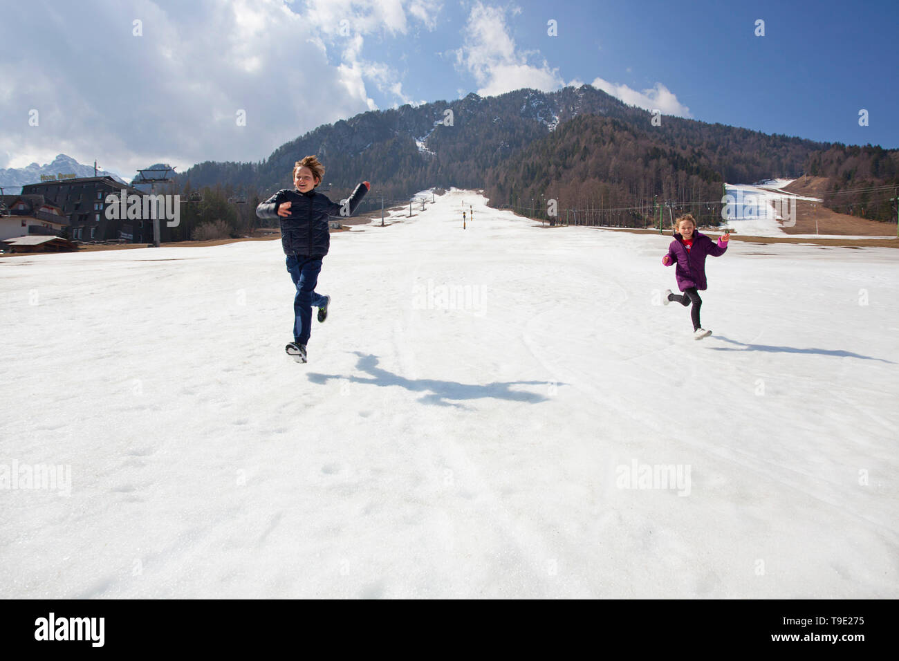 Kinder laufen über verschneite Pisten, Kranjska Gora, Slowenien Stockfoto