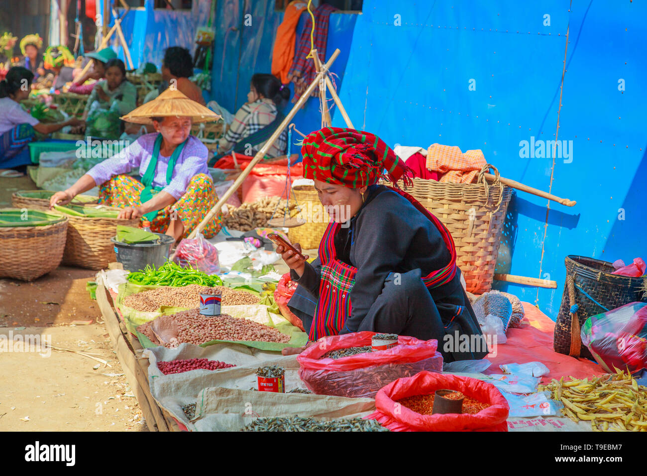Verkäufer überprüft ihr Mobiltelefon (Inle Lake, Myanmar) Stockfoto