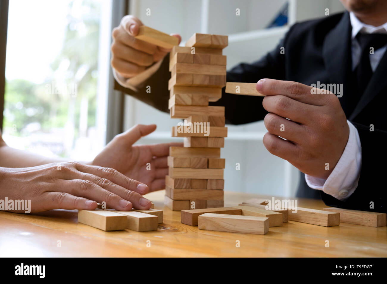 Unternehmer Kommissionierung Holzblöcke die fehlenden Holzblöcke zu füllen und schützen die Holzblöcke zu scheitern. Wachsende Unternehmen Konzept. Stockfoto