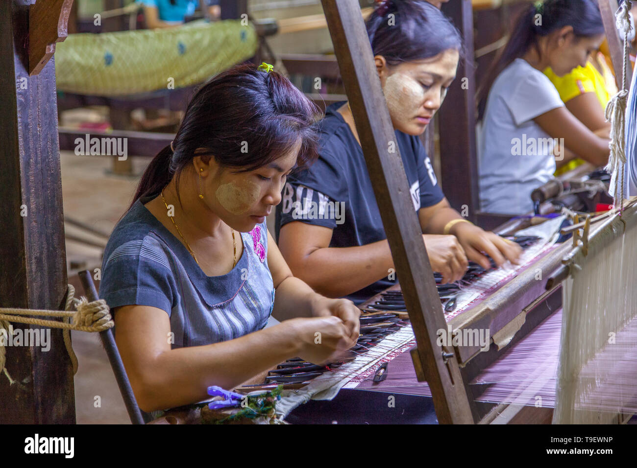 Die jungen burmesischen Frauen am Webstuhl arbeiten Stockfoto