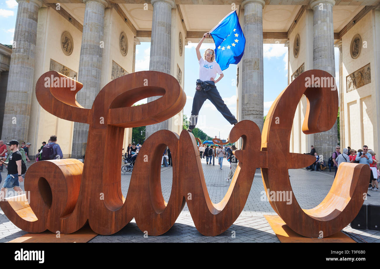 Berlin, Deutschland. 18 Mai, 2019. Die Künstlerin Mia Florentine Weiss steht auf ihre Skulptur "Love Hate' vor dem Brandenburger Tor und Wellen die europäische Flagge. Quelle: Annette Riedl/dpa/Alamy leben Nachrichten Stockfoto