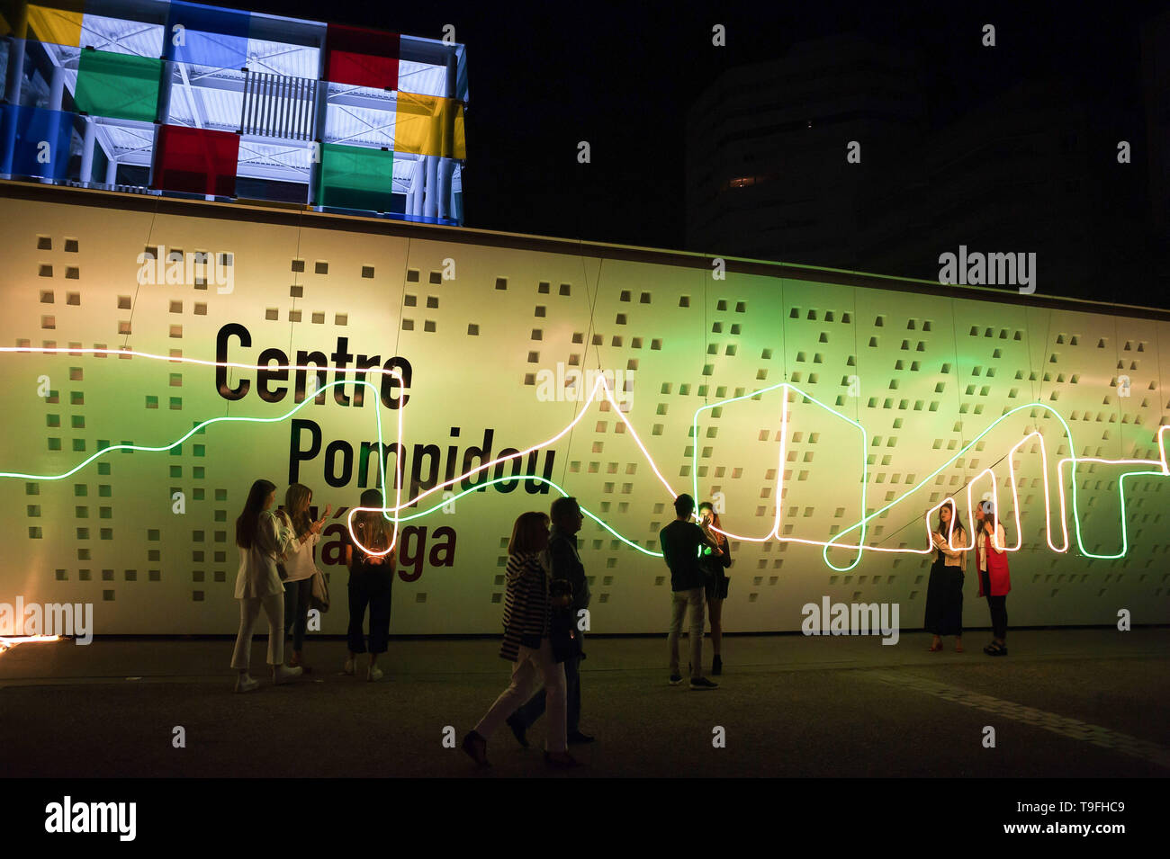 Malaga, Spanien. 19 Mai, 2019. Die Menschen sind vor der Fassade des Centre Pompidou Museum mit einer künstlerischen Beleuchtung und während der Nacht in Weiß" 2019 gesehen. Jeder Mai, Malaga feiert eine kulturelle Nacht mit mehr als 200 Aktivitäten in der Innenstadt wie Performances, Street Art, live Musik und kostenfreie Besuche in allen Museen. Credit: SOPA Images Limited/Alamy leben Nachrichten Stockfoto