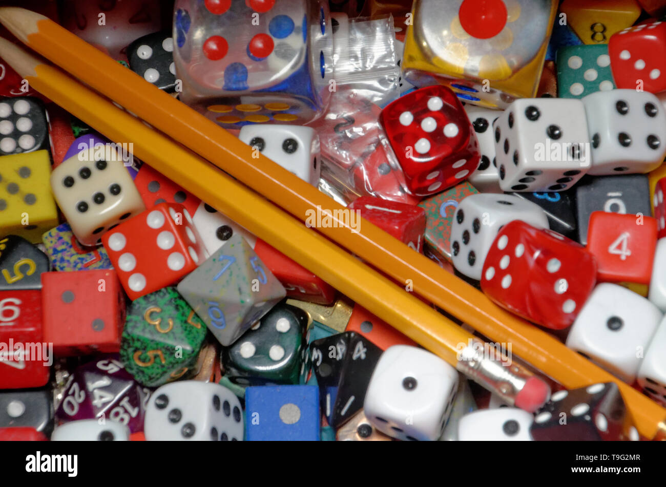 Eine Vielzahl von Dice in verschiedenen Größen und Farben mit zwei Bleistifte Stockfoto