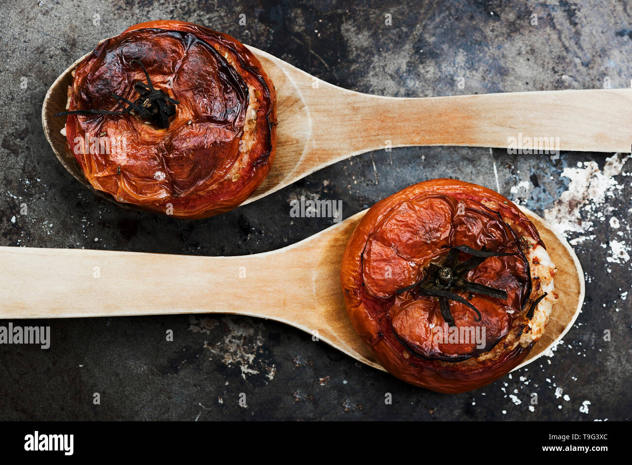 Tomaten mit Reis mit Holzlöffel auf Metallplatte Stockfoto